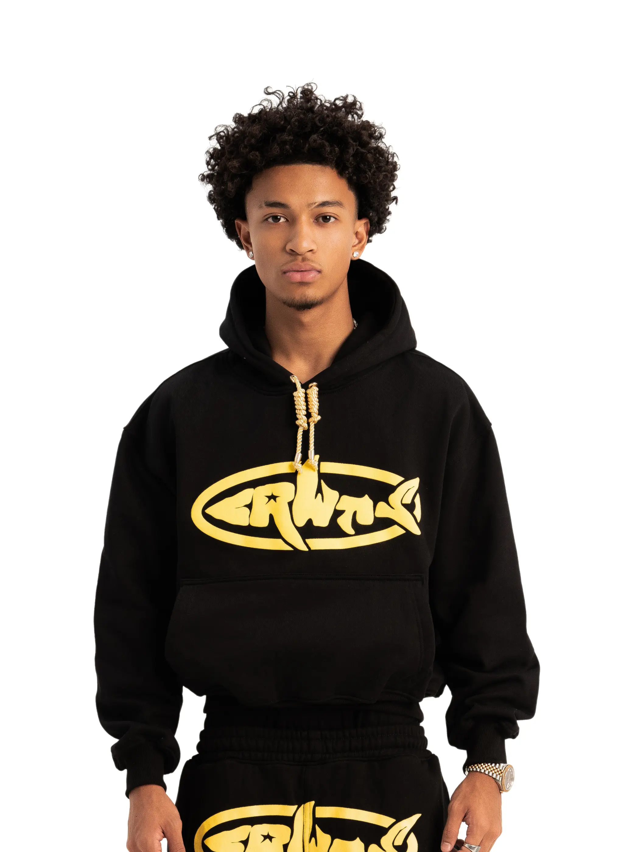 A person wearing a black hoodie with a gold printed logo on the front