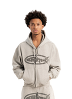 A person wearing a gray hoodie with a felt printed logo on the front.